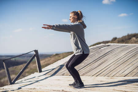Woman enjoys exercising at the old wooden bridge in nature.の写真素材