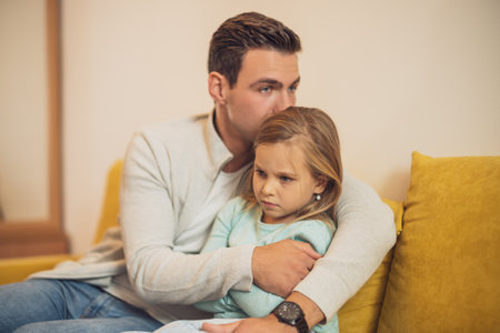 Little girl is angry after conflict with her father  and he is trying to comfort her.の写真素材