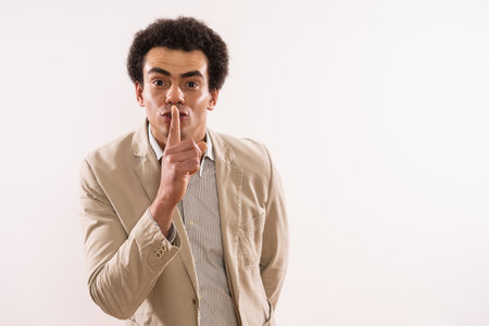 Portrait of a businessman showing silence sign.の写真素材
