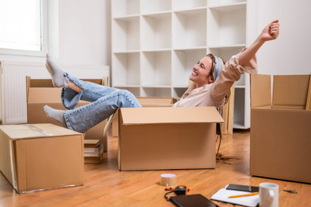 Happy woman having fun while moving into new apartment.