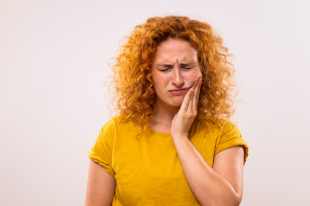 Ginger woman is having toothache.の写真素材