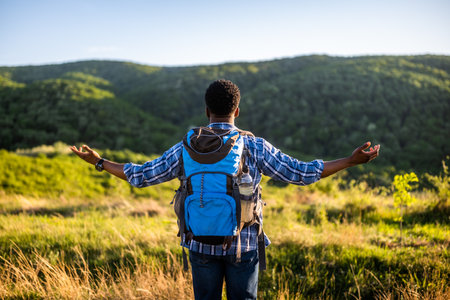 Man hiker with arms raised enjoys in beautiful view in the nature.の写真素材