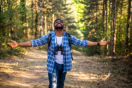 Happy young man hiker with arms raised enjoys in the nature.の写真素材