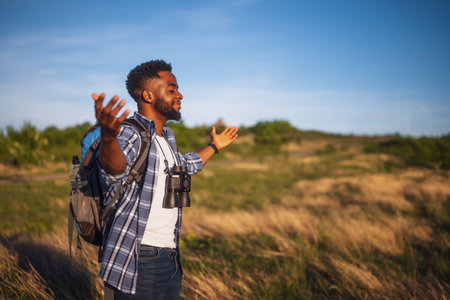 Happy man hiker with arms raised enjoys in the nature.の写真素材