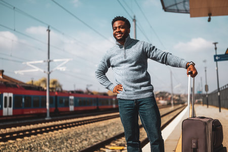Happy man with suitcase standing on railway station.の写真素材