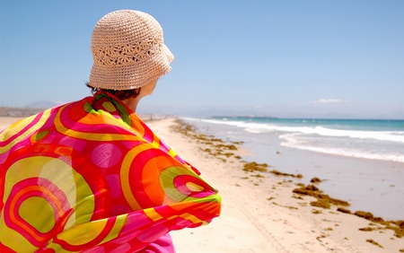 Woman whit hat in a beach a windy dayの写真素材