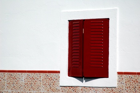 red shutter  window in white wallの写真素材