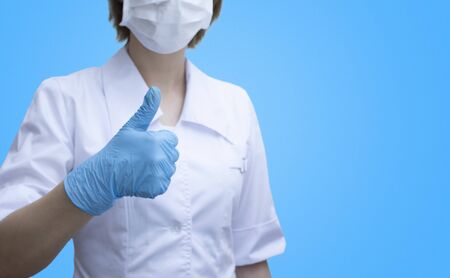 Doctor hand giving thumbs up isolated on blue background. template with space for text.の写真素材