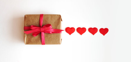 Gift box with decorative hearts on white