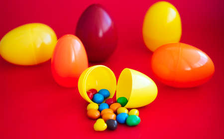 colorful candy spills out of plastic Easter eggs.の写真素材