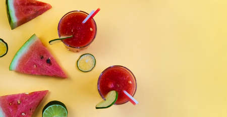 watermelon slices and a glass of smoothies on a yellow background. summer flatlayの写真素材