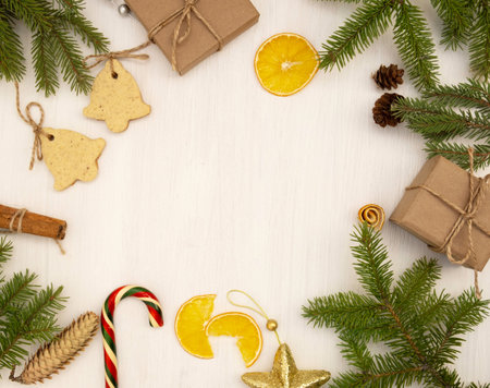 Christmas flat lay. Christmas tree branches, cookies, gifts and caramel on a light wooden...