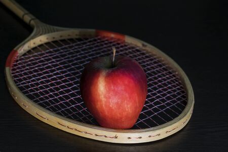 A red Apple and a tennis racket. The concept of a healthy lifestyle.の写真素材