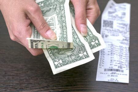 Dollars in hand on the background of the receipt.の写真素材