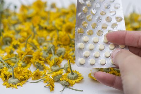 Packaging of tablets against the background of daisies.の写真素材