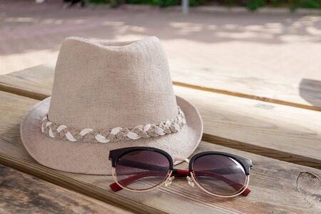 A beautiful summer hat and sunglasses on a wooden table.の写真素材