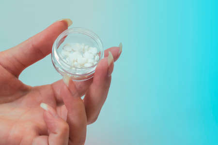 Container with tablets in hand. The pills in the shape of a heart.の写真素材