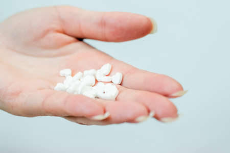 Heart-shaped tablets in the palm of hand.の写真素材