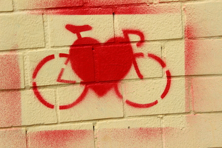 On the bright red paint wall painted bike and heartの写真素材