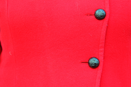 on the red coat hanging black two buttonsの写真素材