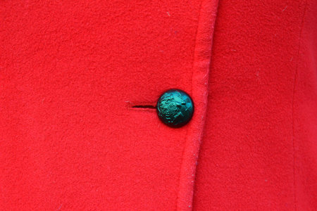 on a red coat hanging button black