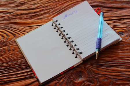 on a wooden board open notepad with penの写真素材