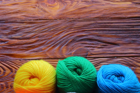 on a wooden board three tangle of threads for knittingの写真素材