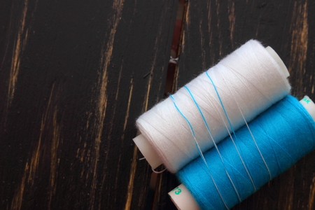 two spools of thread on a wooden boardの写真素材