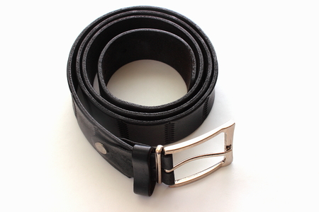 men's belt folded in a circle on a white backgroundの写真素材