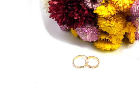 wedding rings and a bouquet of flowers isolated on whiteの写真素材