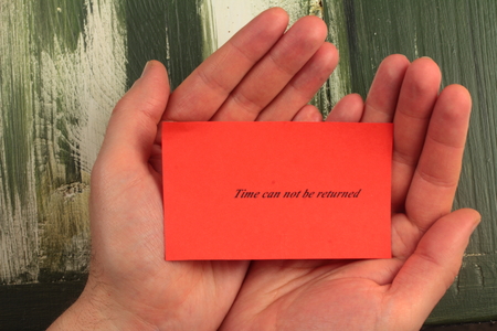 on a sheet of red words written about the timeの写真素材