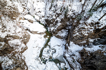 Winter landscape with snow covered valley and frozen river, with small waterfalls shot on long exposureの写真素材