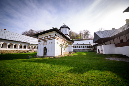 The courtyard of an orthodox monastery with church and living quarters in the countryside of Romaniの写真素材