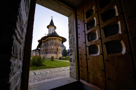 Painted church monastery of Bucovina region in Romania seen through a doorwayの写真素材