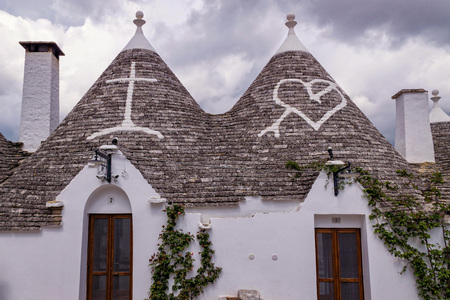 The unique architecture of Alberobello in Italy with conical stone roofs and painted symbolsの写真素材