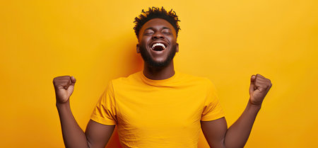 Excited african american man in yellow t-shirt on yellow backgroundの素材