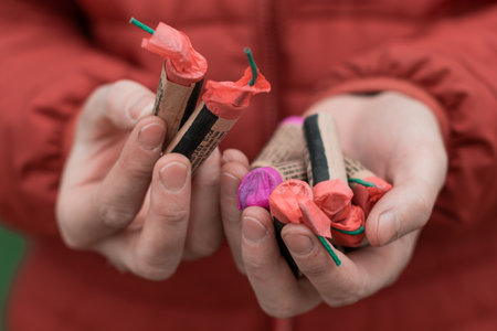 Man Holding Firecrackers in his Hand. Guy Getting Ready for New Year Fun - CloseUp Shotの写真素材