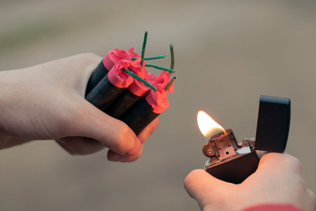 Man Lighting Up Several Firecrackers in his Hand Using Gasoline Lighter. Guy Getting Ready for New...