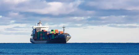Modern grey container ship moving in still waterの写真素材