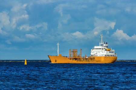 Yellow cargo tanker ship moving at the clear summer dayの写真素材