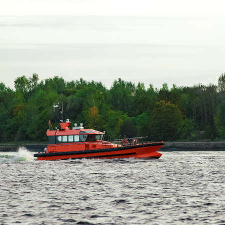 Orange pilot ship sailing on the Daugava riverの写真素材
