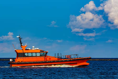 Orange pilot boat moving by the river in Europe. Rescue serviceの写真素材