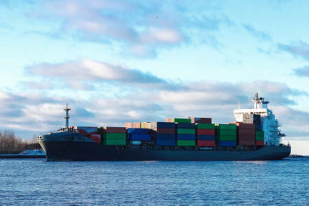 Modern grey container ship moving in still waterの写真素材