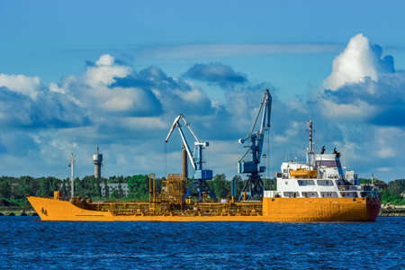 Yellow cargo tanker ship moving at the clear summer dayの写真素材