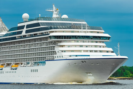 White cruise liner moving to the sea at cloudy dayの写真素材