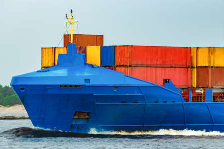 Blue cargo container ship fully loaded underwayの写真素材