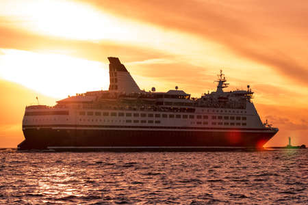 Cruise liner leaving Riga. Passenger ferry sailing at hot sunsetの写真素材