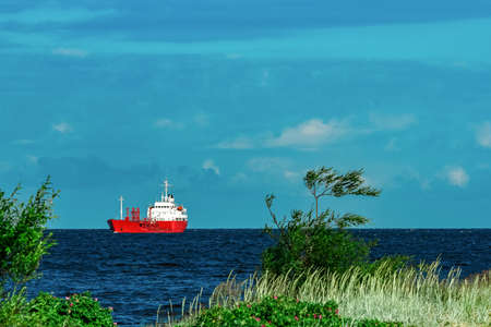 Red cargo tanker ship moving by the riverの写真素材