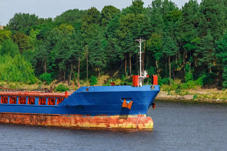Blue cargo ship with long reach excavator moving to the portの写真素材