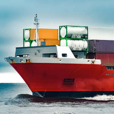 Red cargo container ship's bow in cloudy dayの写真素材